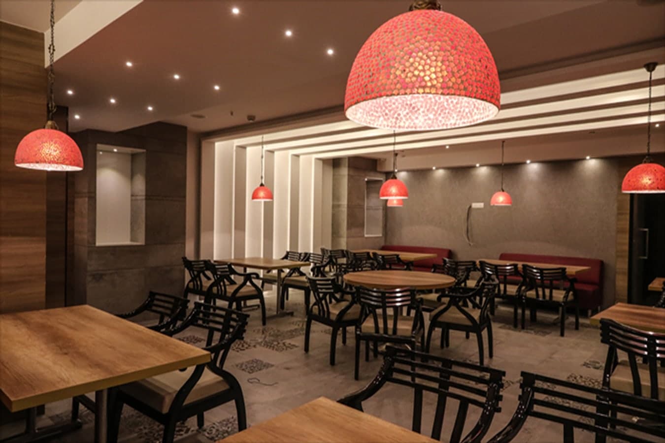 Aroma restaurant with a large red mosaic pendant, dark wooden chairs and red banquettes