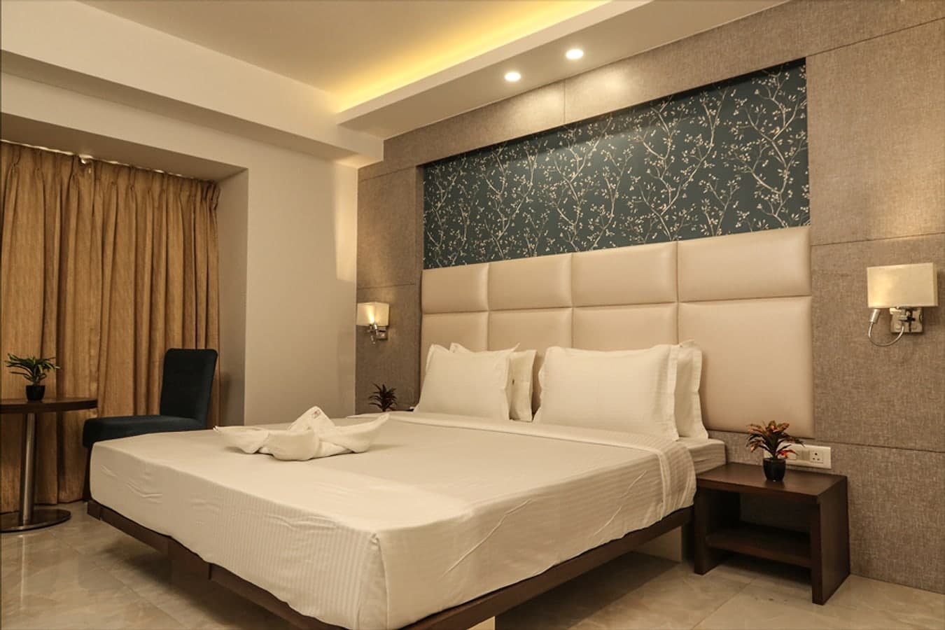 Luxury King room with a king bed, padded headboard and teal botanical wallpaper